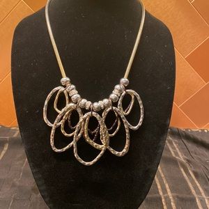 Chico’s gold necklace with silver, gold, and bronze hoops